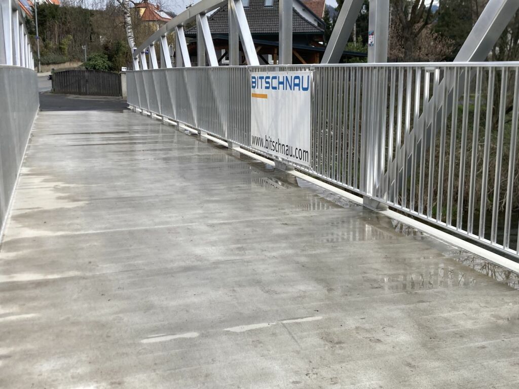 neue Aluminiumbrücke Murinsel Bruck an der Mur mit Regenlacken gebaut von der Firma Bitschnau aus Nenzing