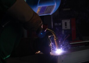 Der Meister im aluminium-schweißen schweißt einen Teil einer Alubrücke zusammen.