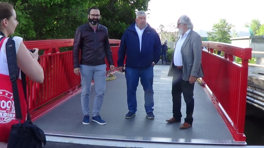 Rote Aluminiumbrücke für Rad- und Fußweg mit schlanker Tragstruktur in Felixdorf