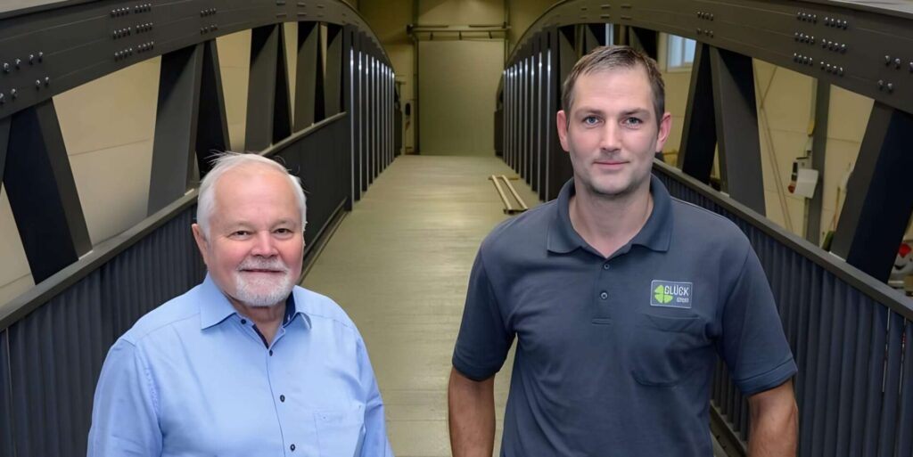 Werner Glück und Andreas Weh auf einer Brücke in der Werkshalle