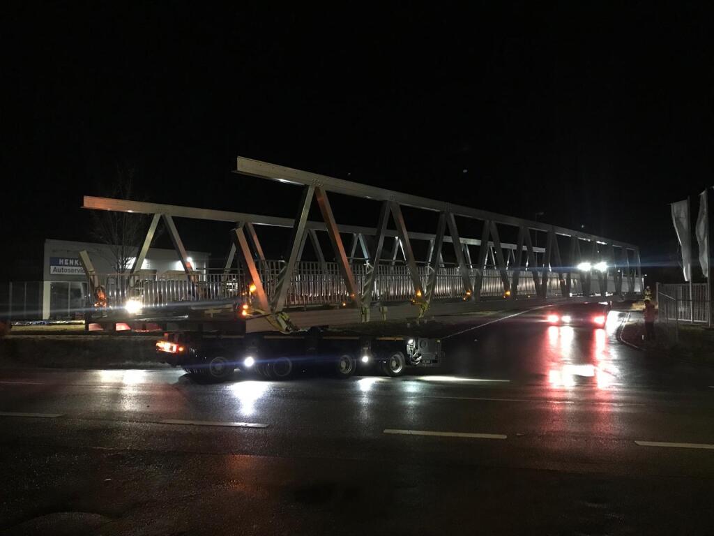 5,00 Meter breite Aluminiumbrücke auf einem Schwertransport beim Abbiegen auf einer Straße.